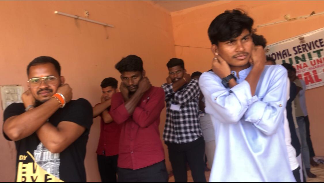 Positioning of arms by volunteers during Super Brain Yoga at Telangana University NSS I & IV units Special Camp organized at Suddapally village.