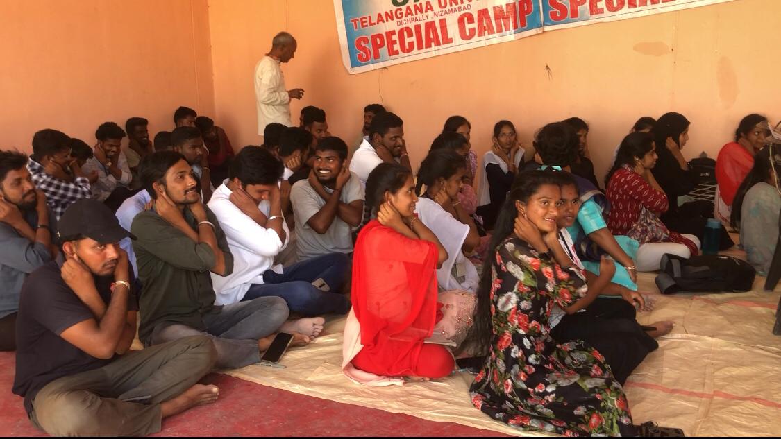 Positioning of fingers on earlobes by volunteers during Super Brain Yoga at Telangana University NSS I & IV units Special Camp organized at Suddapally village.