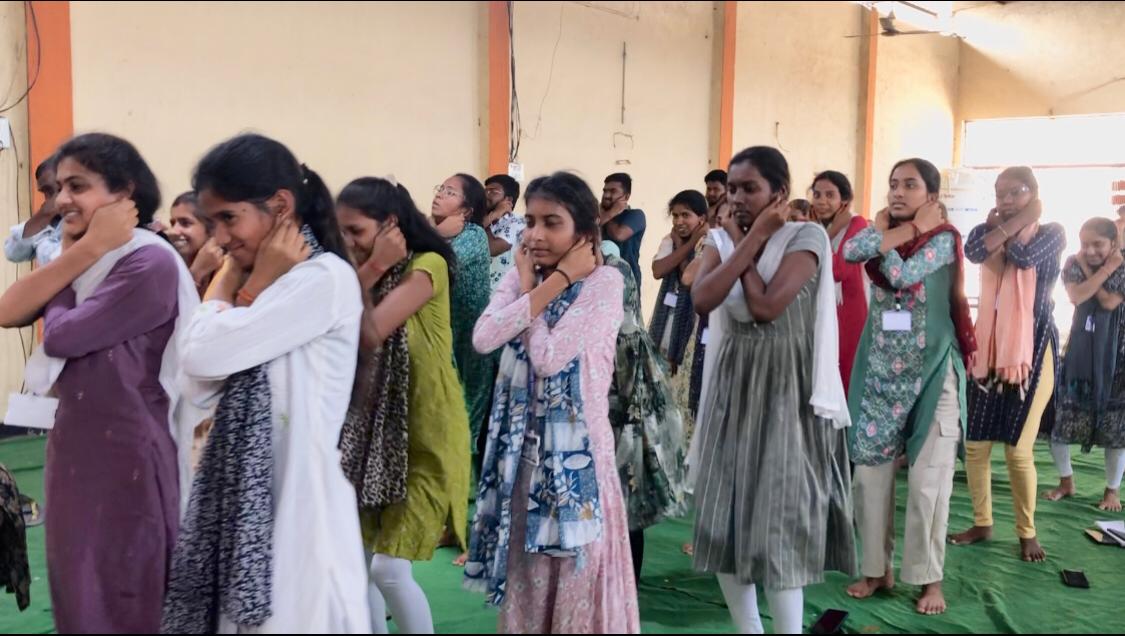 Positioning of fingers on earlobes-Workshop on Super Brain Yoga at NSS, Unit-II, Telangana University at Dichpally Village.