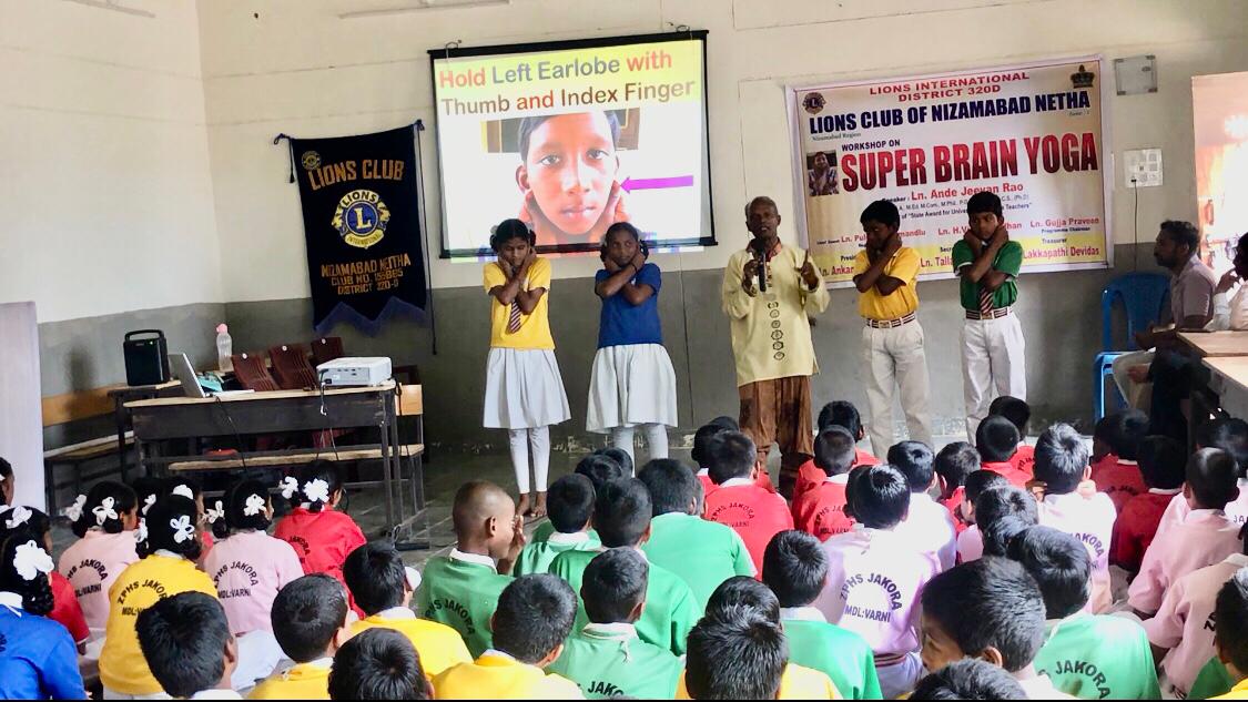 Positioning of fingers on earlobes - Workshop on Super Brain Yoga at Zilla Parishad High School, JAKORA, Varni Mandal, Nizamabad Dist.