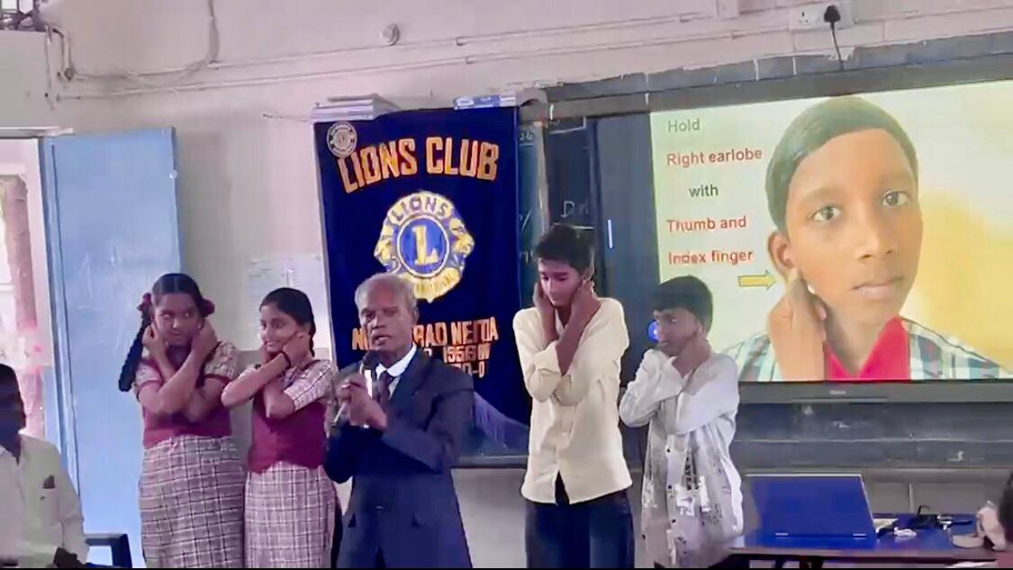 Positioning of fingers on earlobes demonstration - Workshop on  Super Brain Yoga at P.M. Sri Zilla Parishad High School, MALLARAM, Nizamabad Mandal & District.